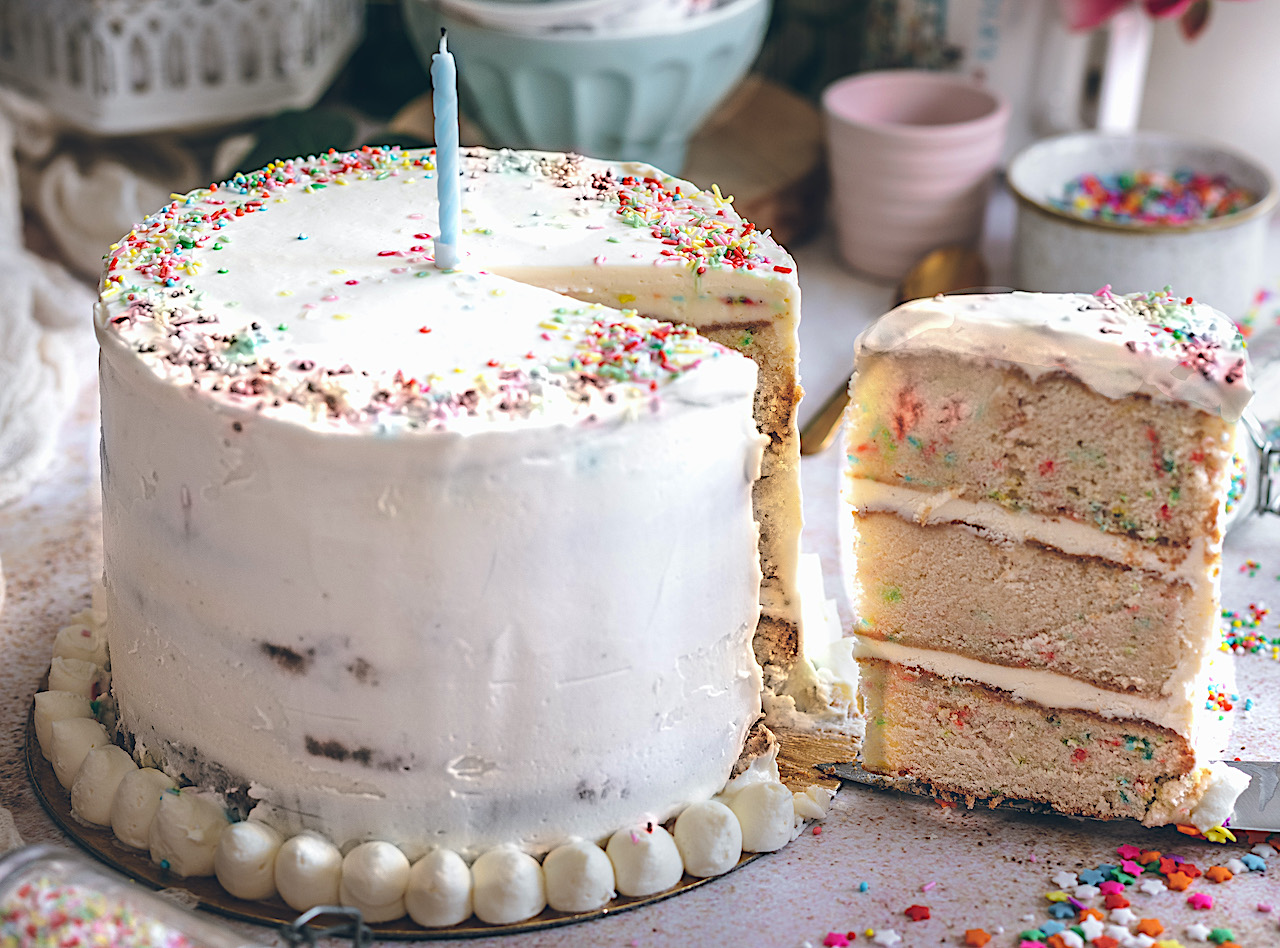 Tarta de cumpleaños feliz con confeti de colores y chocolate blanco.